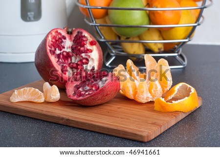 Peeled tangerine and cut pomegranate on the kitchen table