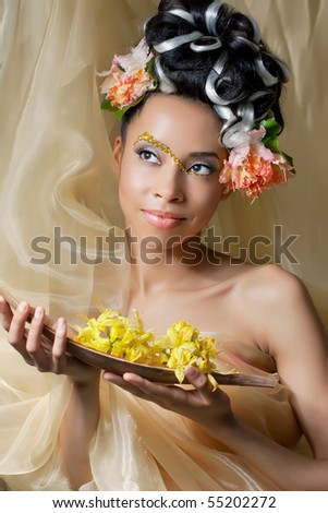 Portrait of a beautiful young girl with curly hairstyle and fantasy makeup