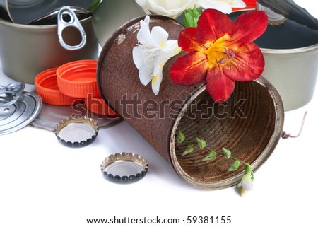 Flowers on a rusty tin, with a pile of rubbish, isolated on white