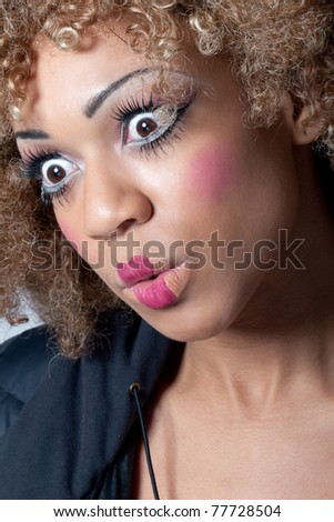 Young woman with clown make-up and wig looking surprised and intrigued, eyes wide open