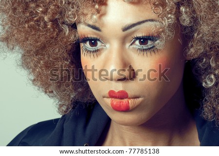 Young beautiful woman with clown make-up and wig looking thoughtful and ready for performance, closeup shot