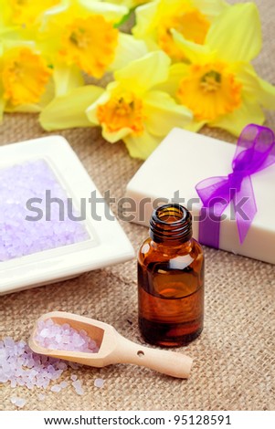 Spring spa: bath salt with soap and essential oil, closeup shot, focus on salt, spoon and bottle