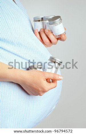 Pregnant woman with hospital containers for giving urine samples, pregnancy health checking concept