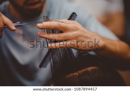 Barbershop. Close-up of man haircut, master does the hair styling in barber shop
