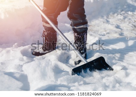 City service cleaning snow winter with shovel after snowstorm yard. sunlight