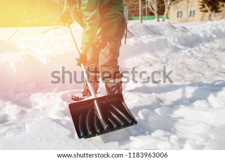 City service cleaning snow winter with shovel after snowstorm yard. sunlight