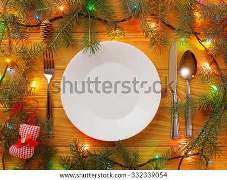 Empty Plate, fork, knife and spoon on wooden table. Christmas background