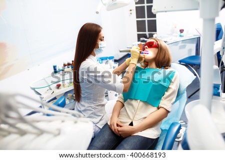 Overview of dental caries prevention.Woman at the dentist\'s chair during a dental procedure. Beautiful Woman smile close up. Healthy Smile. Beautiful Female Smile