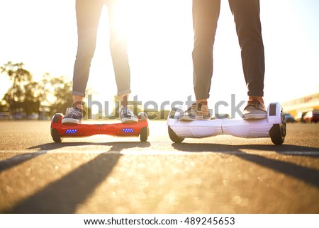 young man and woman riding on the Hoverboard in the park. content technologies. a new movement. Close Up of Dual Wheel Self Balancing Electric Skateboard Smart