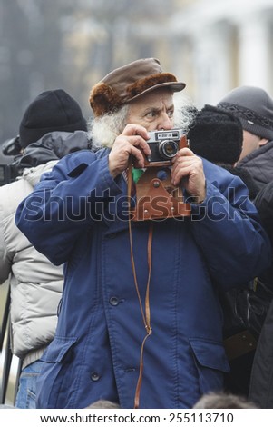 Kyiv, Ukraine - 18 Januar 2015: Old man takes pictures on retro camera FED 5V in 1975 release in the USSR.
