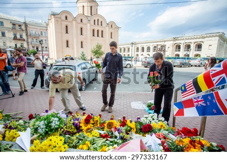People place flowers and light candles in commemoration of the victims of Malaysia Airlines MH17 plane accident in eastern Ukraine, in front of the Dutch embassy in Kiev, Ukraine, 17 July 2015.