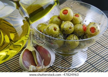 green olives stuffed with pimento , spiced with basil and olive oil