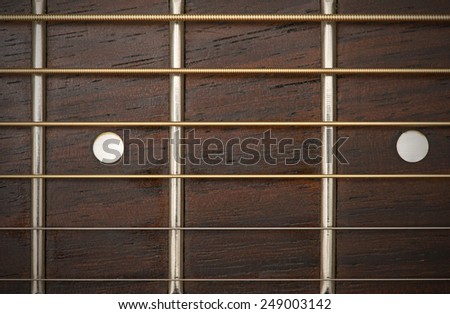 close-up macro of guitar strings and fret board