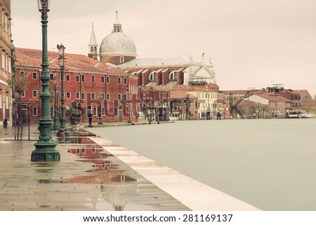 long time exposure of Chiesa del Santissimo Redentore (Church of the Most Holy Redeemer) and shoreline in Venice (Venezia) on a rainy day in autumn, Italy, Europe,\
vintage filtered style