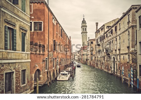 Canal in Venice (Venezia) with old buildings, boats and the leaning belfry tower of San Giorgio dei Greci, Italy, Europe, vintage filtered style