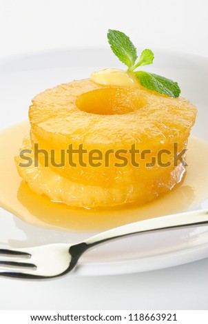 Canned pineapple rings fried in caramel sauce on a white plate