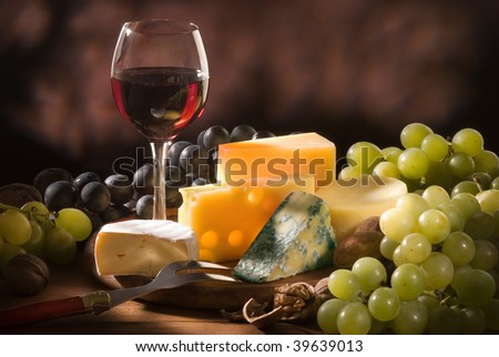 Glass of red wine with various types of cheese and garnishes