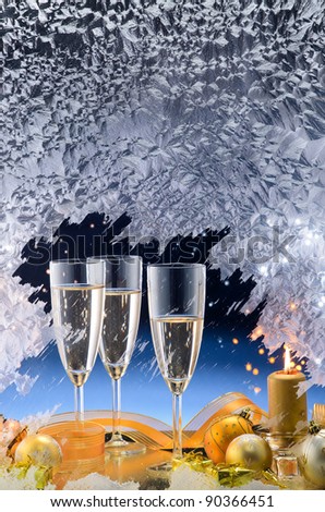 Frosted window, champagne glasses and Christmas decoration