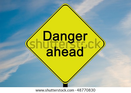 A yellow and black road sign with the words Danger ahead.