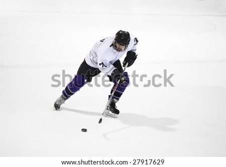Ice hockey player skates with the puck