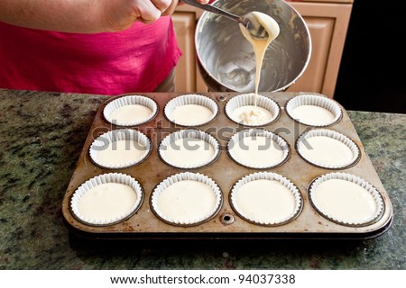 Making cupcakes, pouring into the cupcake tin