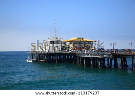 SANTA MONICA, CALIFORNIA - JULY 1: Santa Monica Pier stretches out into the Pacific Ocean on July 1, 2012 in Santa Monica, California. The pier opened in 1909 and now has an aquarium and a carousel.