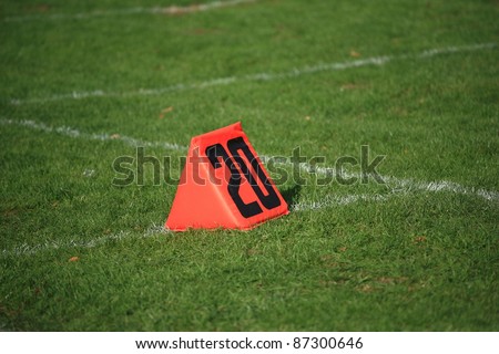 Football Field Yard Marker - Twenty 20 yard line on grass playing field.