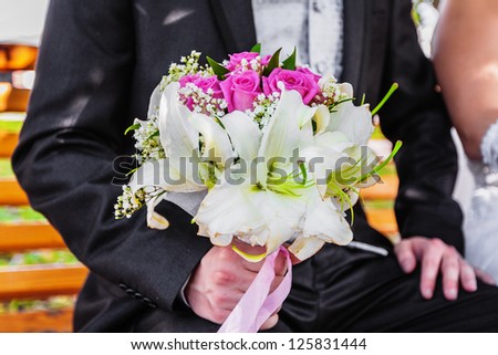 Wedding flower bouquet of pink roses in male hand