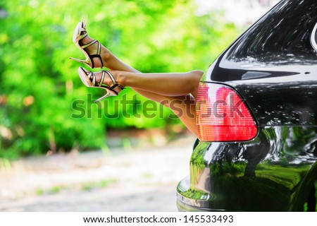 Beautiful woman\'s legs showing out of the car