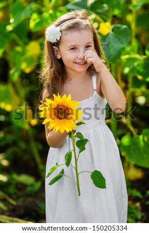 Portrait of young smiling girl with sunflower