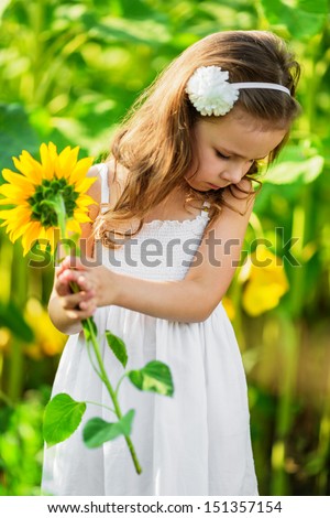 Portrait of young girl in white dress with sunflower