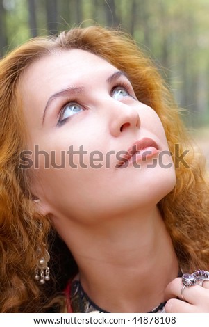 A beautiful ginger-haired girl looking up