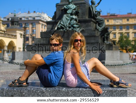two children posing against the backdrop of the famous area of the Polish city of Krakow
