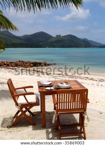 Table with two chairs at the ocean shore in Seychelles
