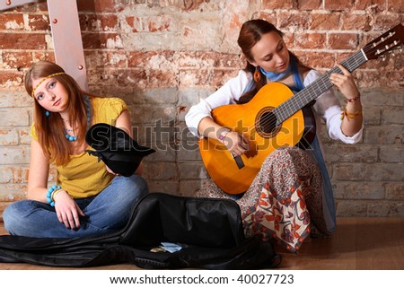 Two young girls playing acoustic guitar and this make money
