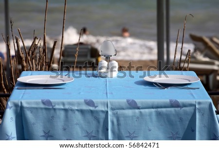 served tables in beach restaurant, sea background