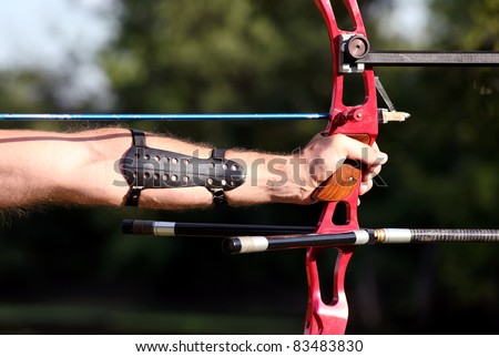 Bow hunter hands holding compound bow, closeup
