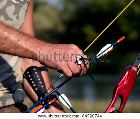 Bow hunter hands holding compound bow, closeup