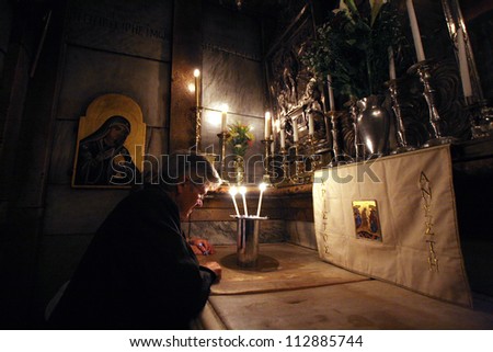 JERUSALEM - OCTOBER 01: Pilgrims pray at the tomb of Jesus in the Church of the Holy Sepulchre, traditional site of the crucifixion, burial, and resurrection of Jesus, on October 01, 2006.