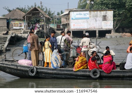GOSABA, INDIA - JANUARY 19: wooden boat crosses the Ganges River January 19, 2009 in Gosaba, West Bengal, India. To use a small wooden is easy, fast and cheap way how to cross the Ganges River.
