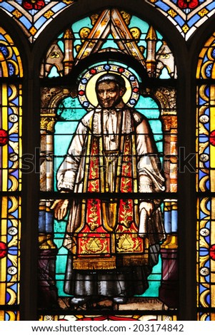 PARIS, FRANCE - NOV 11, 2012: Saint Vincent de Paul, stained glass from Church of St-Germain-l\'Auxerrois founded in the 7th century, was rebuilt many times over several centuries.