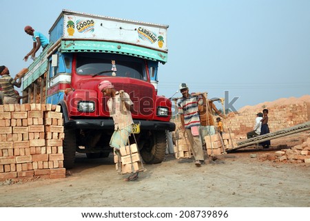 SARBERIA,INDIA, JANUARY 16: Brick field workers carrying complete finish brick from the kiln, and loaded it onto a truck on January 16, 2009 in Sarberia, West Bengal, India.