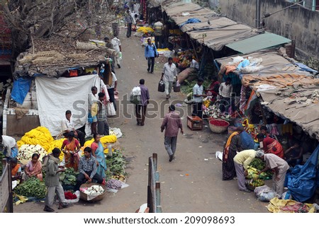 KOKATA, INDIA - FEBRUARY 15: People buying and selling flowers and garlands at the flower market next to a railway track on February 15, 2014 in Kolkata (Calcutta), West Bengal, India