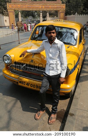 KOLKATA, INDIA - FEBRUARY 14: Indian taxi driver posing in front of his cab in Kolkata on February 14, 2014. The car is Hindustan Ambassador, manufactured since 1958.
