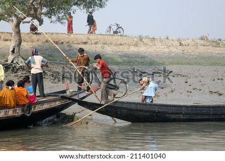 GOSABA, INDIA - JANUARY 19: wooden boat crosses the Ganges River January 19, 2009 in Gosaba, West Bengal, India. To use a small wooden is easy, fast and cheap way how to cross the Ganges River.