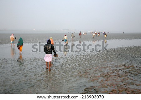 CANNING TOWN, WEST BENGAL, INDIA - JANUARY 17: During low tide the water in the river Malta falls so low that people walk to the other shore in Canning Town, India on January 17, 2009.