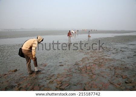 CANNING TOWN, INDIA - JANUARY 17, 2009: During low tide the water in the river Malta falls so low that people walk to the other shore in Canning Town, India