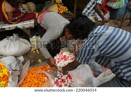 KOKATA, INDIA - FEBRUARY 15: People buying and selling flowers and garlands at the flower market next to a railway track on February 15, 2014 in Kolkata (Calcutta), West Bengal, India