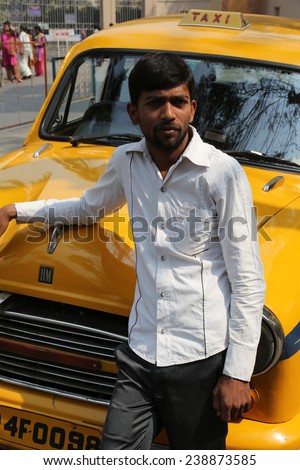 KOLKATA, INDIA - FEBRUARY 14: Indian taxi driver in front of his cab in Kolkata on February 14, 2014. The car is Hindustan Ambassador, manufactured since 1958.