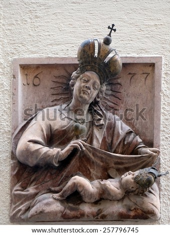 SALZBURG, AUSTRIA - DECEMBER 13, 2014: Virgin Mary with baby Jesus, statue on house facade Salzburg, Austria on December 13, 2014.